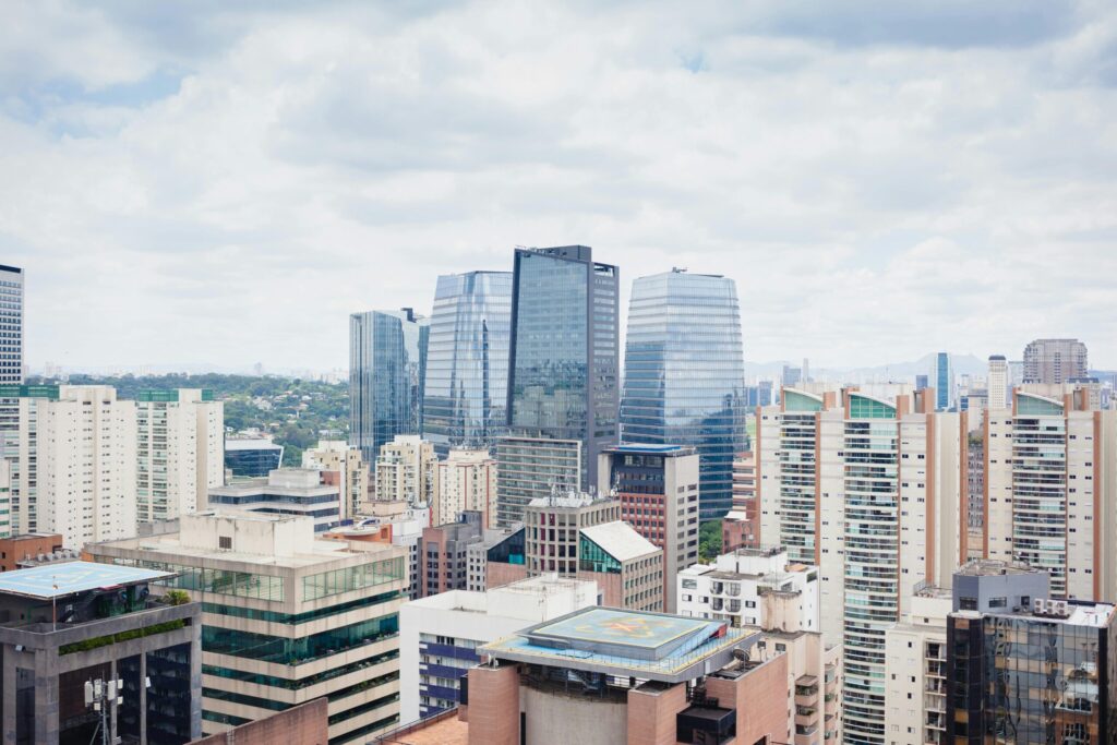 City skyline with modern glass skyscrapers under a cloudy sky.
